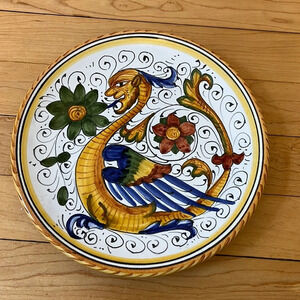Italian Deruta pottery hand painted. 7.5” diameter with hanging holes.